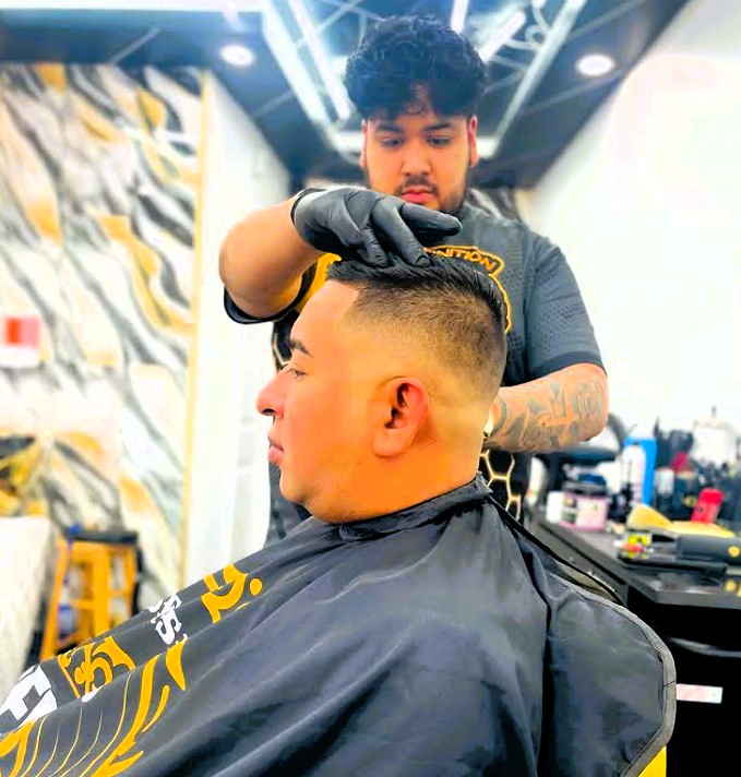 barber buzzing hair at barber shop in Norwalk